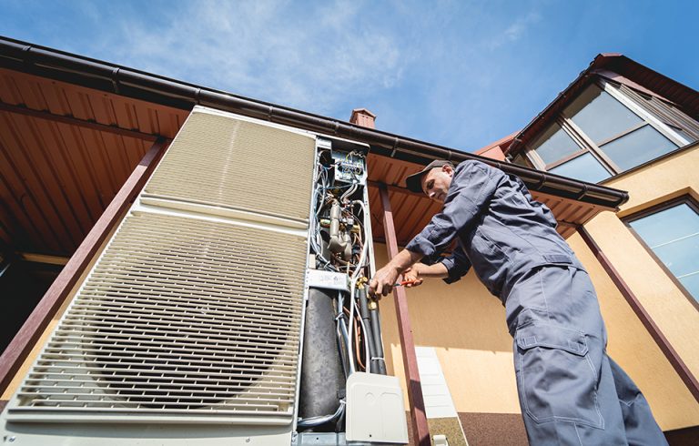 Certified HVAC technician servicing a home heating and cooling system