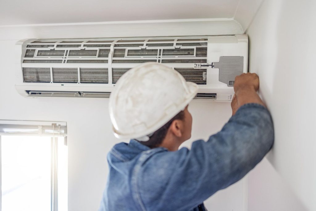 HVAC technician diagnosing and repairing an air conditioning system